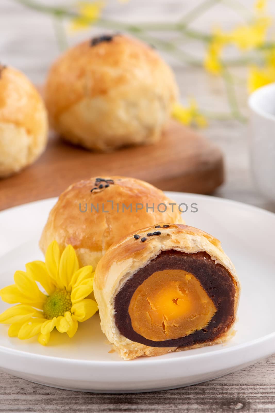 Moon cake yolk pastry, mooncake for Mid-Autumn Festival holiday, top view design concept on bright wooden table with copy space