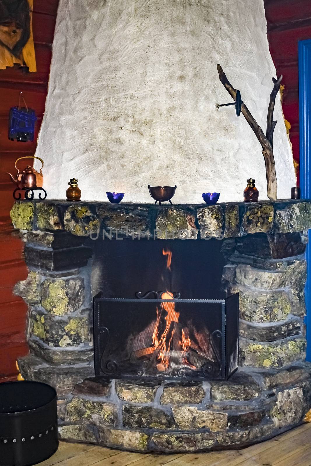 Old stone and wood fireplace in a Norwegian cabin in Hemsedal.