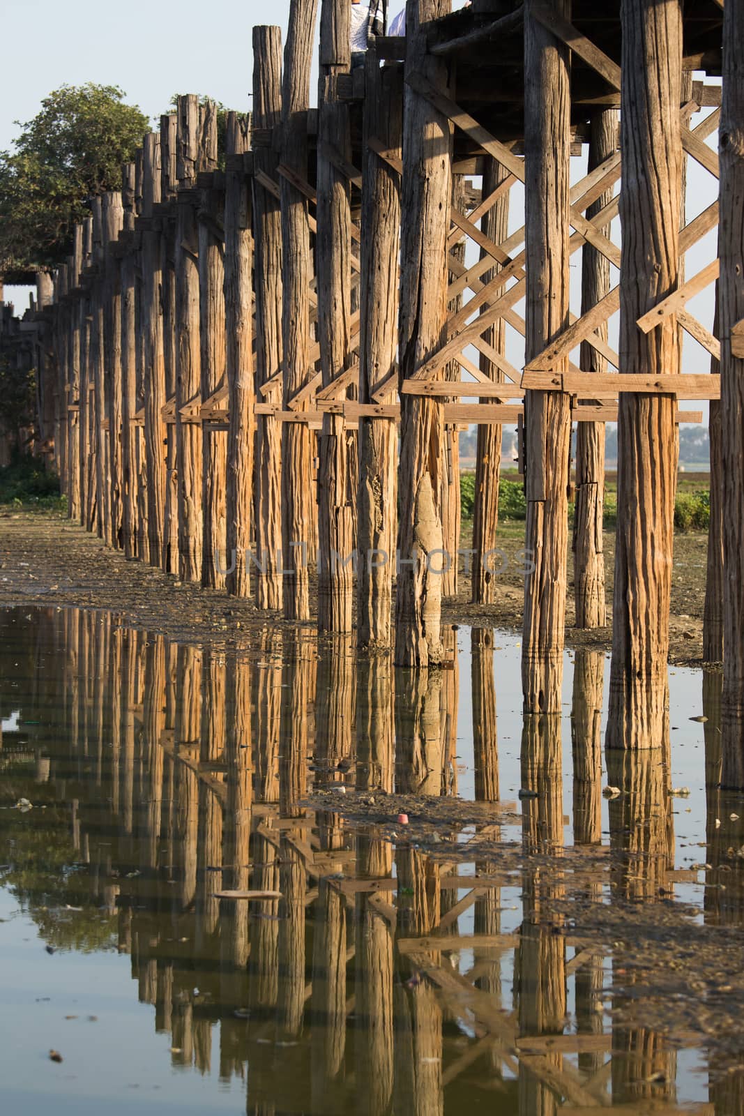 Teak support poles of U Bein Bridge Taungthaman Lake near Amarapura in Myanmar Reflections in water . High quality photo