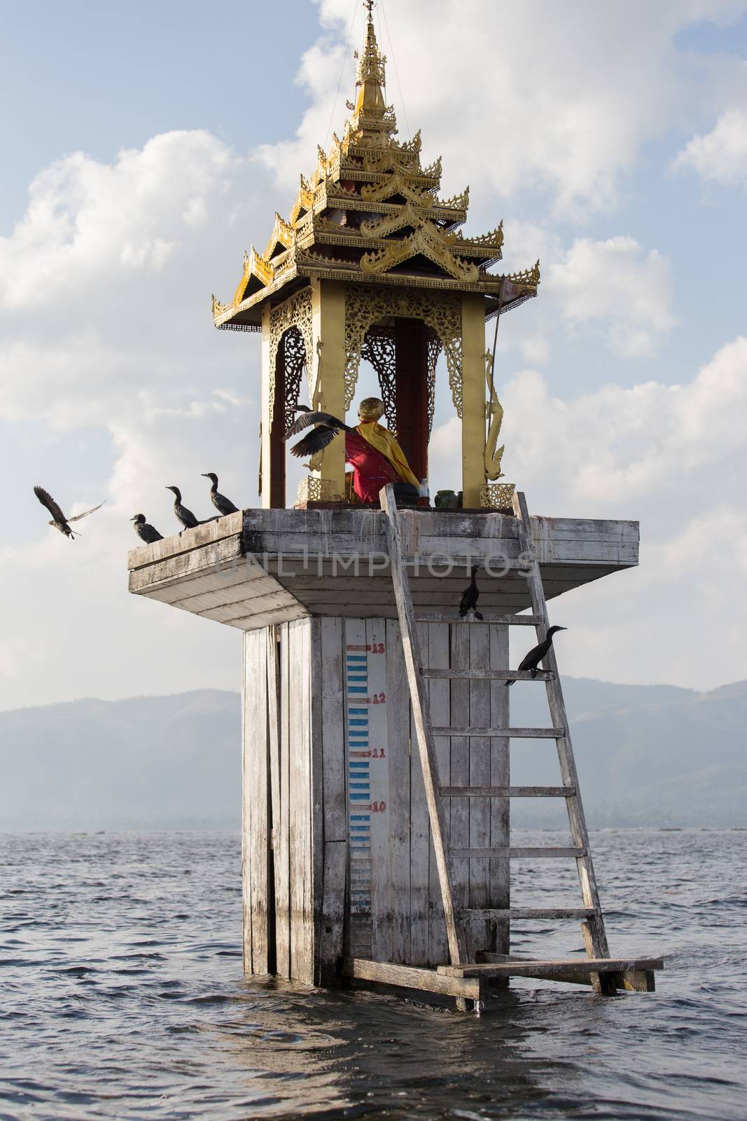 Fishermen's Buddhist shrine water level marker Inle Lake Myanmar . High quality photo