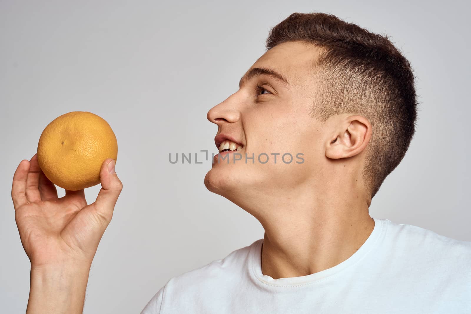 A man with an orange and a white t-shirt on a light background cropped view of the model by SHOTPRIME