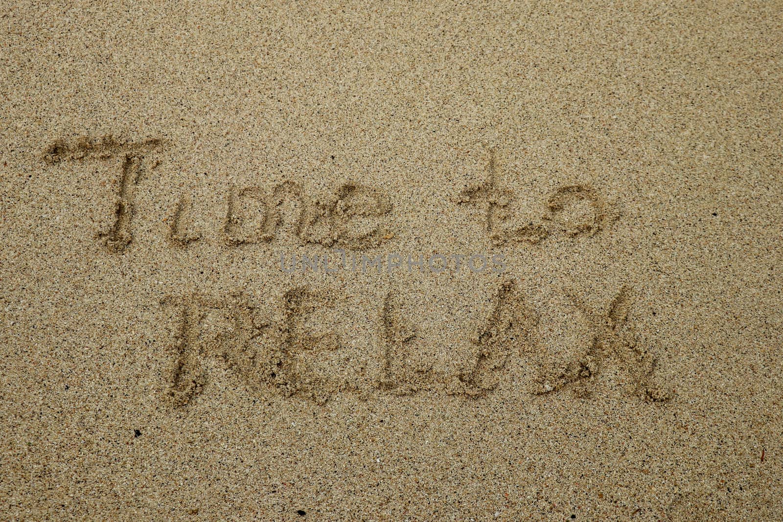 time to relax, concept written on sandy beach.