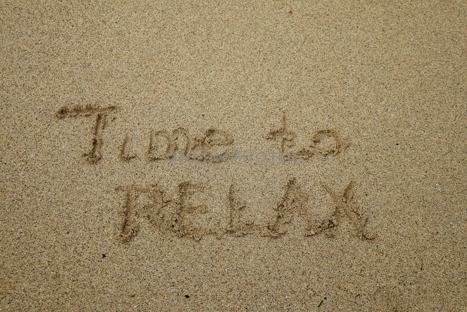 time to relax, concept written on sandy beach.