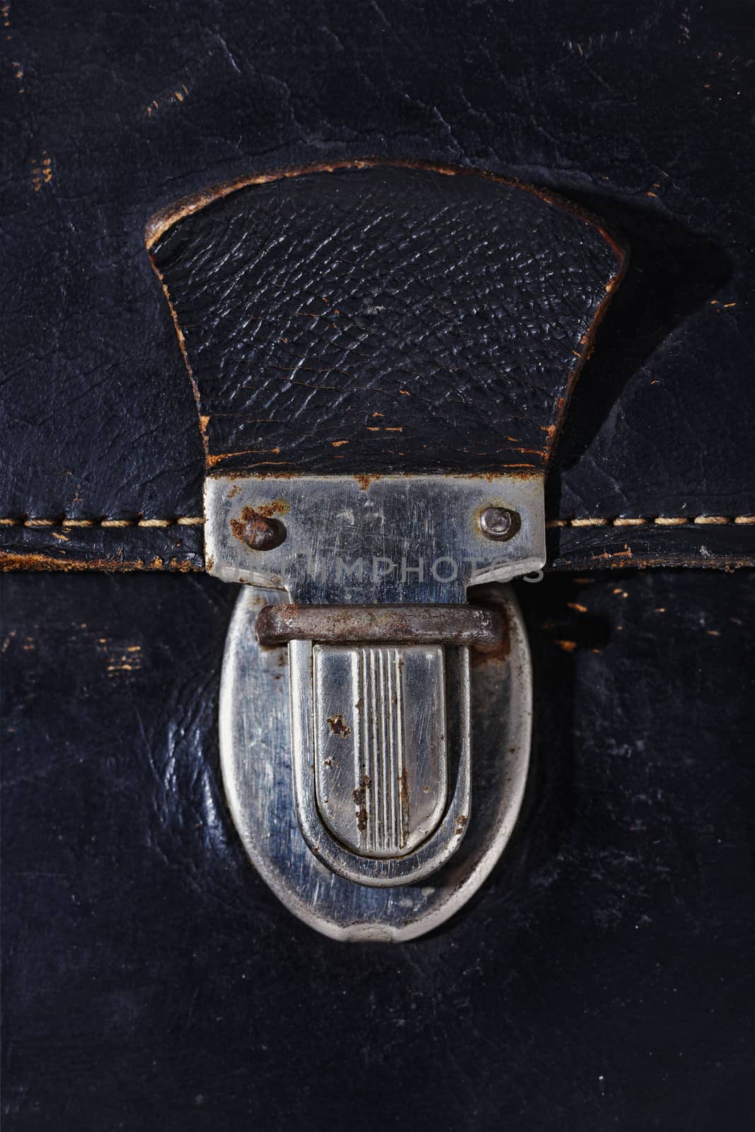 Detal of old metal bag press push lock , old black leather bag with yellow thread, rusty metal