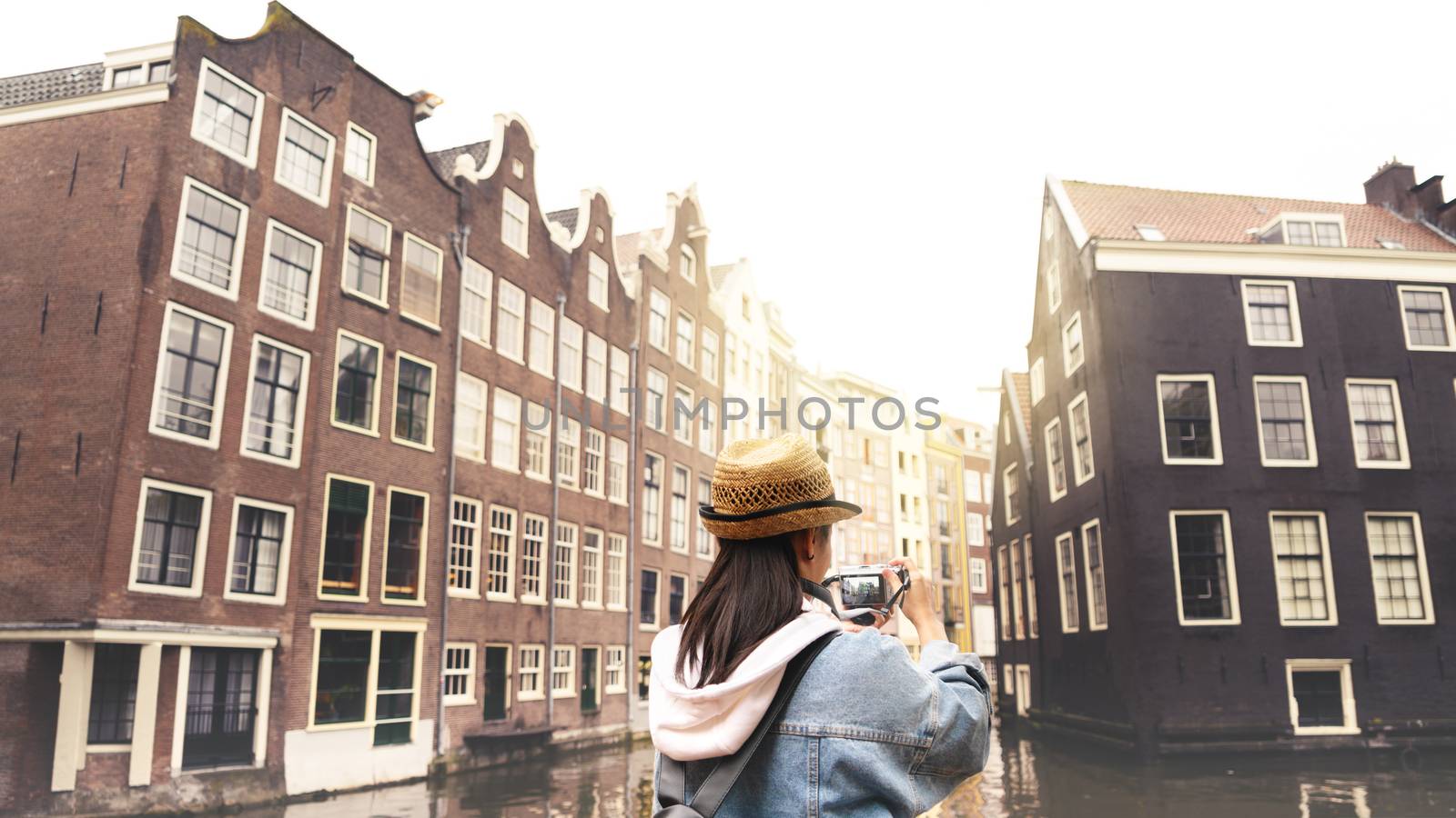 Outdoor lifestyle portrait of pretty young woman having fun in the city in Europe with digital camera travel photo of photographer Making pictures in hipster style