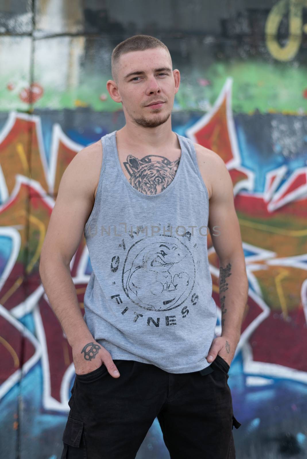 A bully guy in a sports shirt near a wall with graffiti by Mykola_Kondrashev