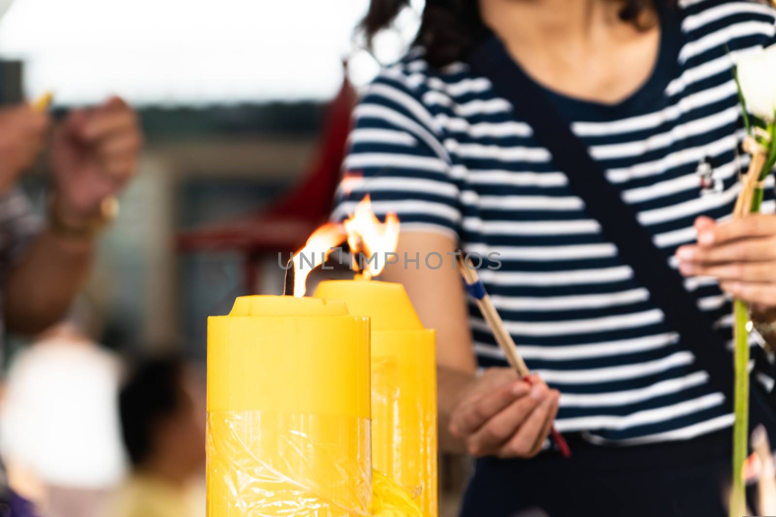 Lighting the candle pray to Buddha, big candle and Flame lit by the big candle's fire.