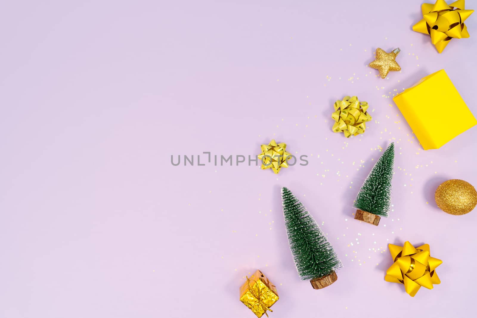 Christmas decoration. Gifts, yellow and golden decorations on purple background. Christmas, winter, new year concept. Flat lay, top view, copy space