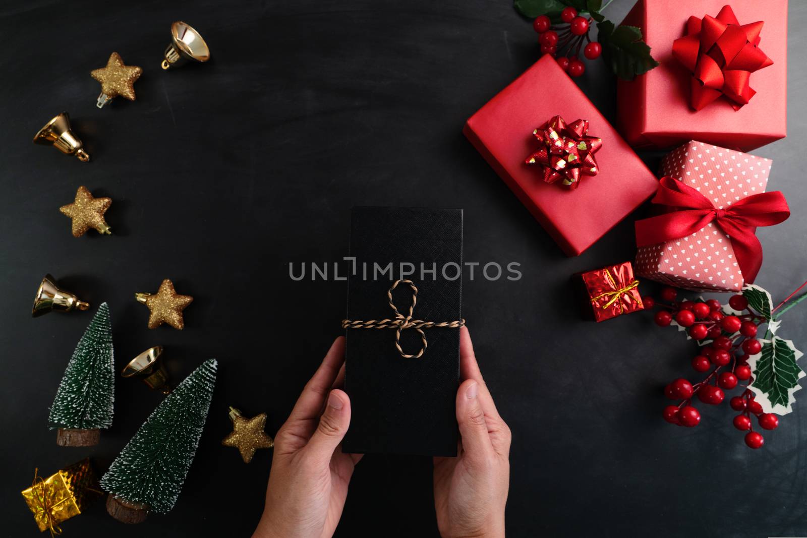 Hand holding christmas present in xmas decoration background