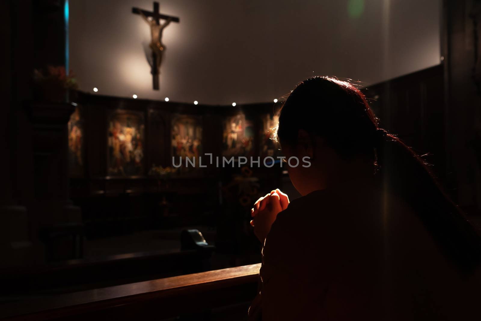 depressed women sitting in the low light church and praying to jesus on the cross, International Human Rights day concept
