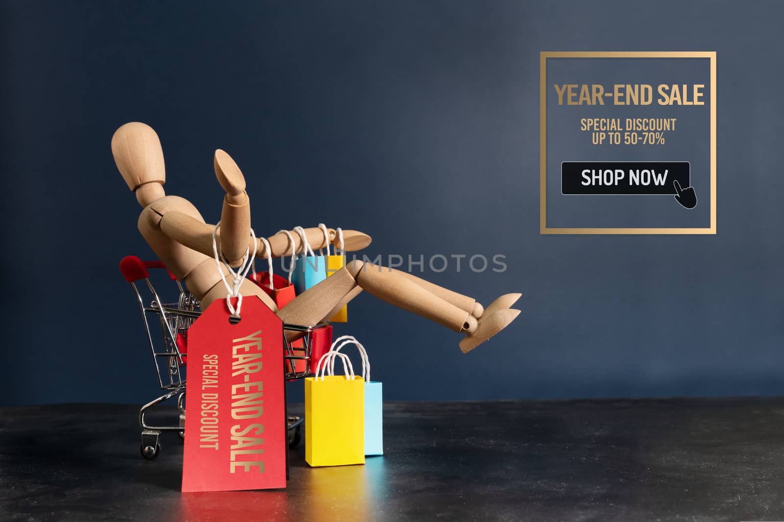 Year-End sale, wooden doll sitting on shopping cart with shopping bag