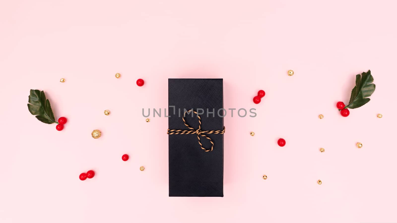 Christmas Gift box, red cherry and golden decorations on pink background. Christmas, winter, new year concept. Flat lay, top view, copy space