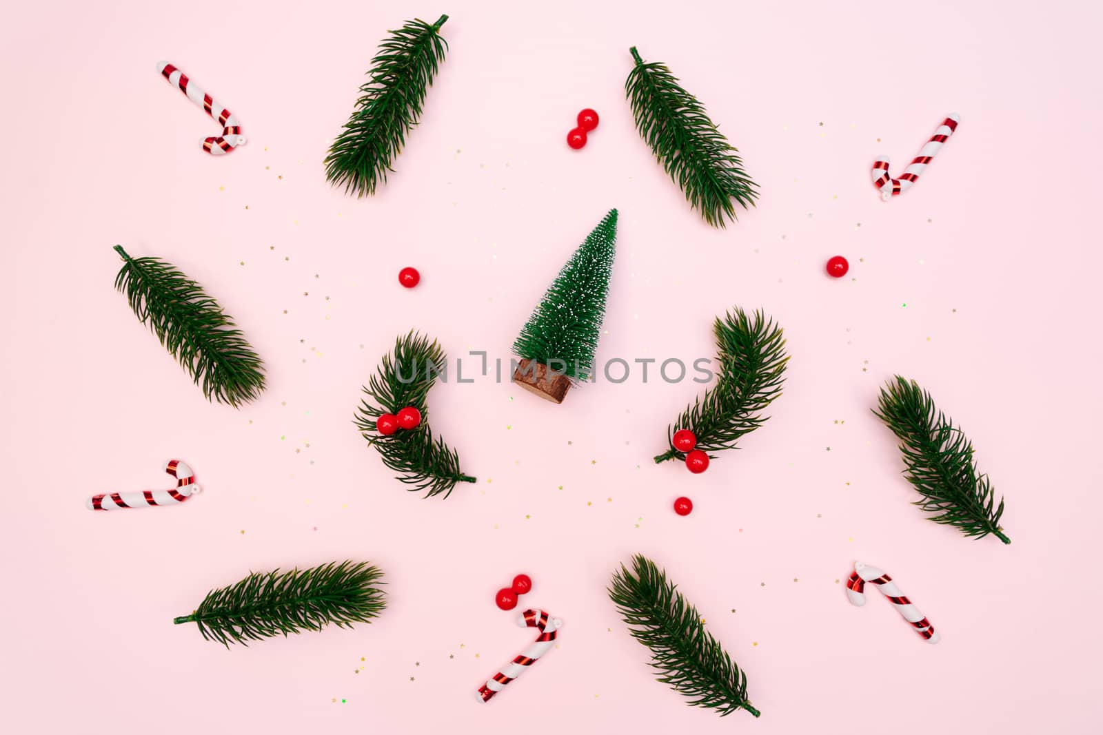 Christmas pine tree with xmas decoration on pink background, flat lay composition