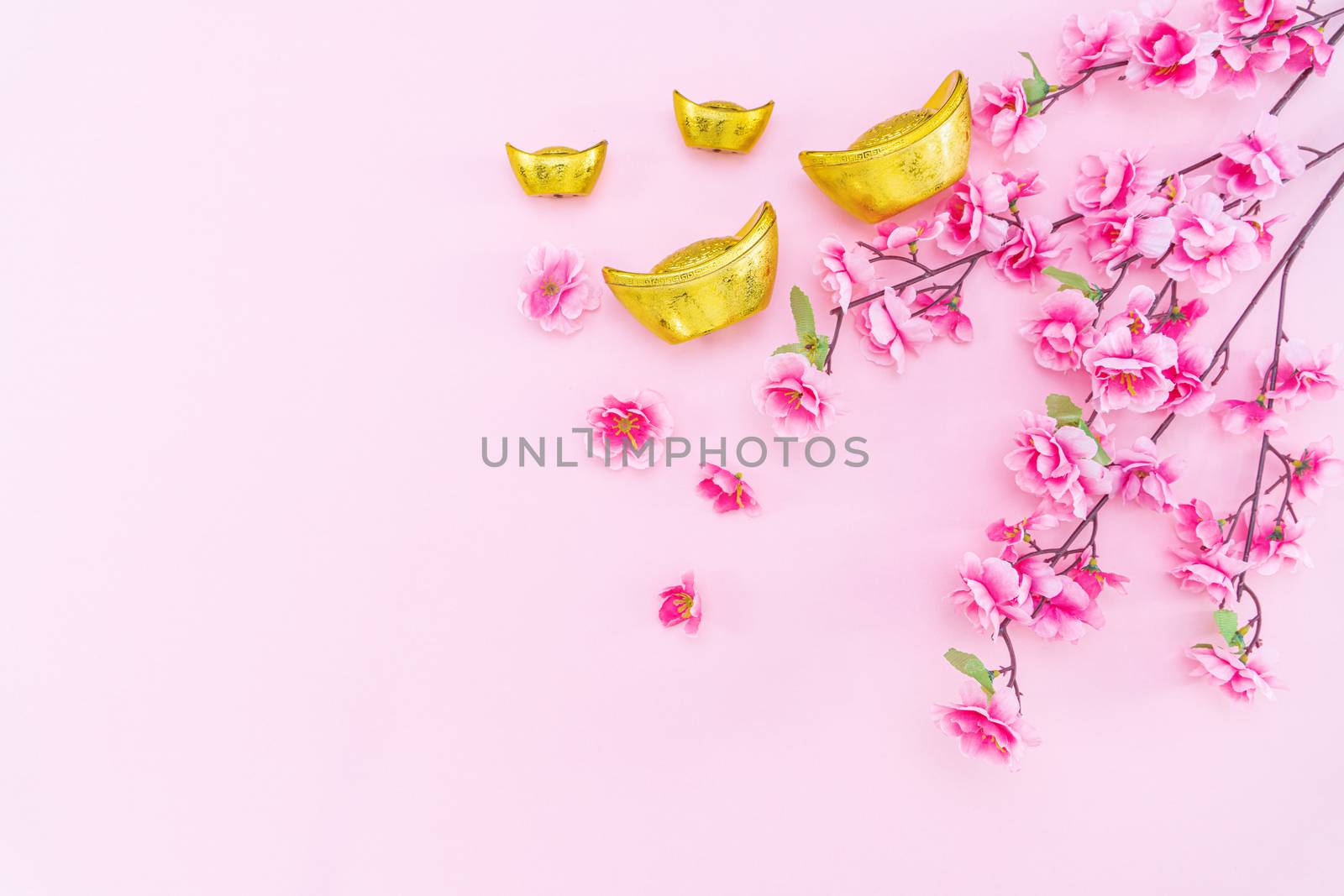 Flat lay Chinese lunar new year gold money and flower on pink background