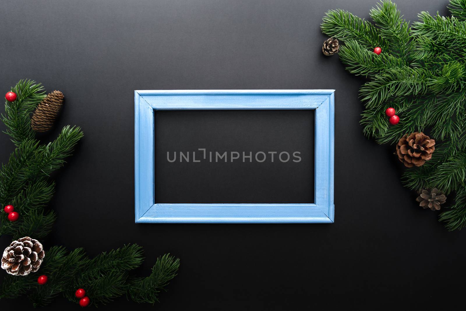 Christmas pine tree and photo frame with xmas decoration on black background