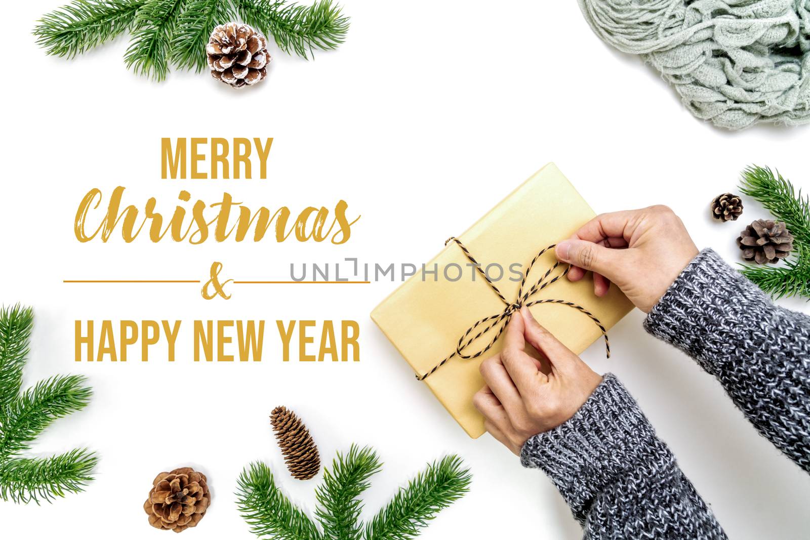 Christmas winter composition. Woman hands wrapping Christmas gifts box with pine cones, fir branches on white background. Flat lay, top view, copy space