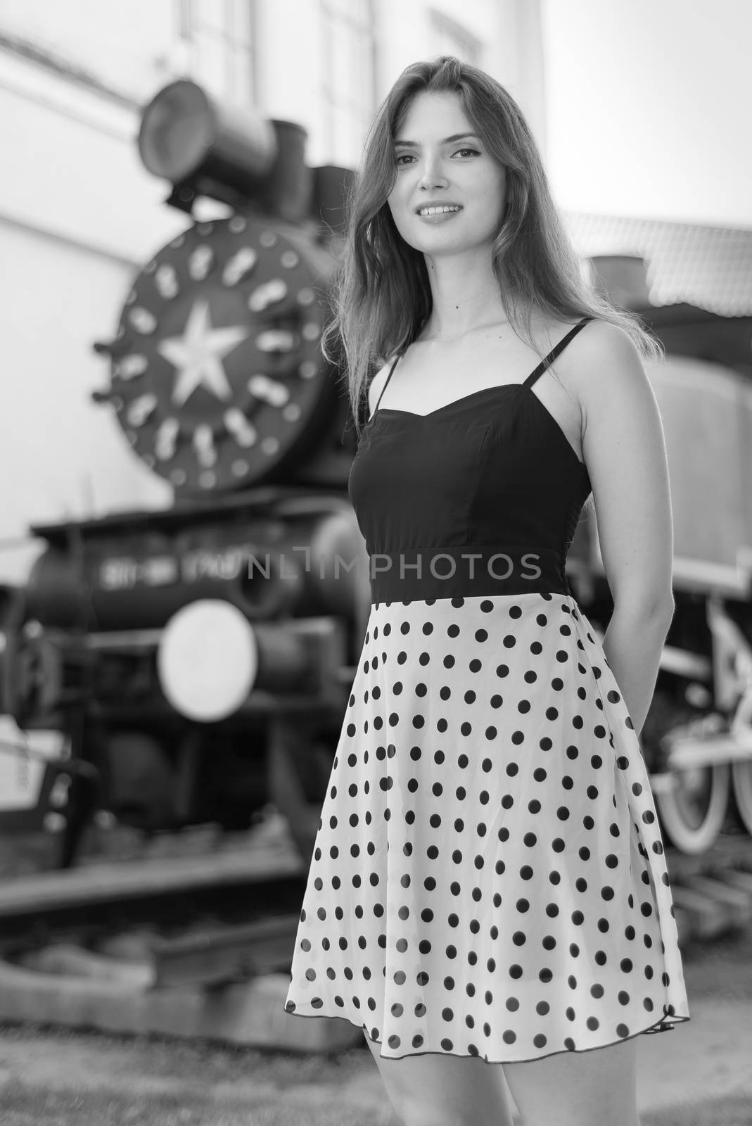 Beautiful girl in a white-black dress with polka dots.