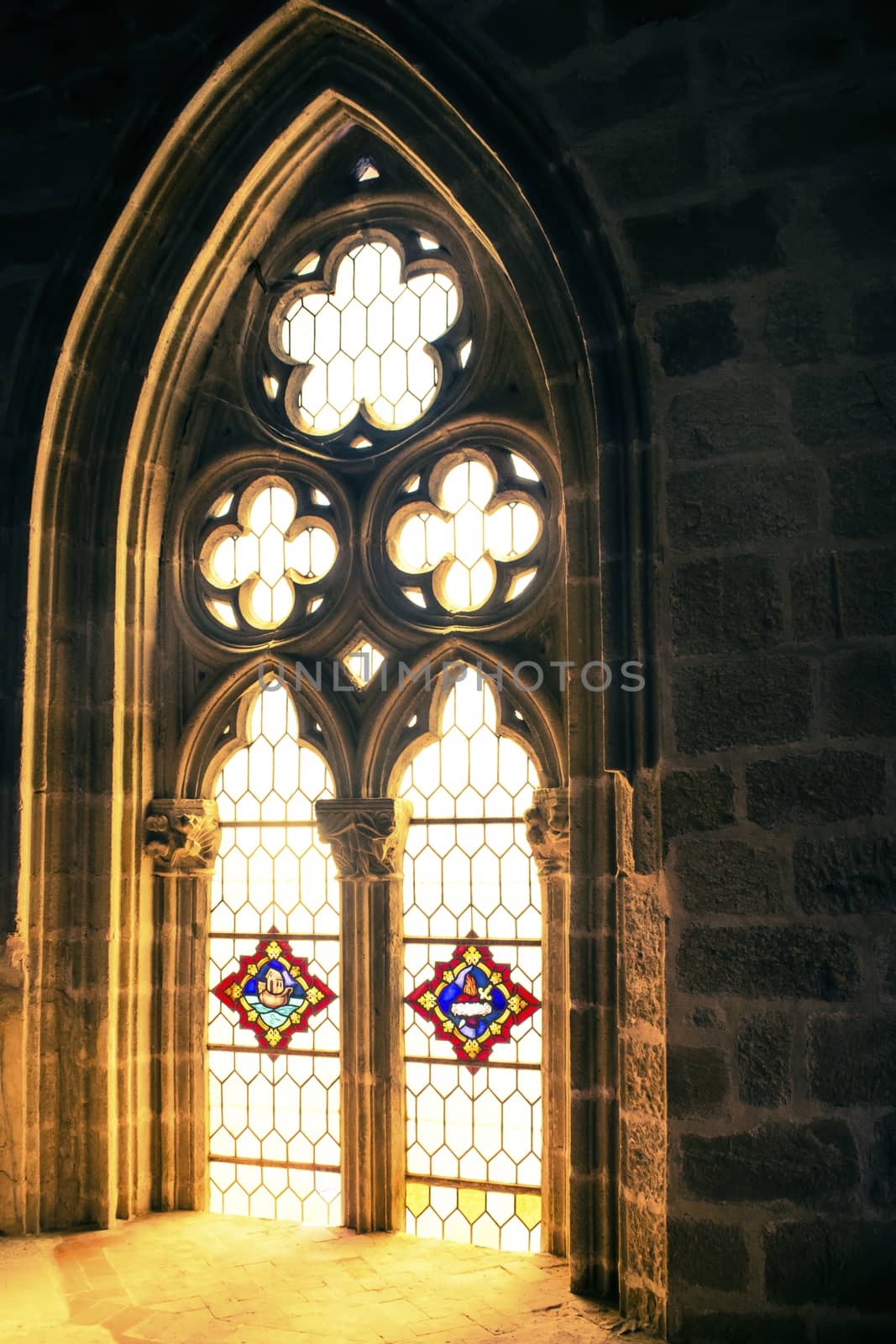 Sunlight shining through stained glass of gothic window of a church. by kb79