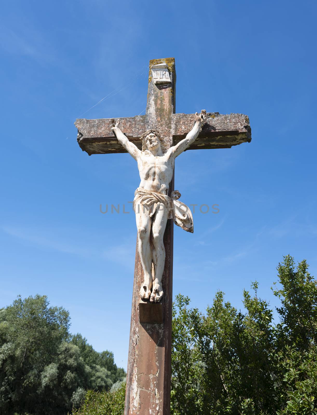 statue of jesus christ on cross in france. under blue sky
