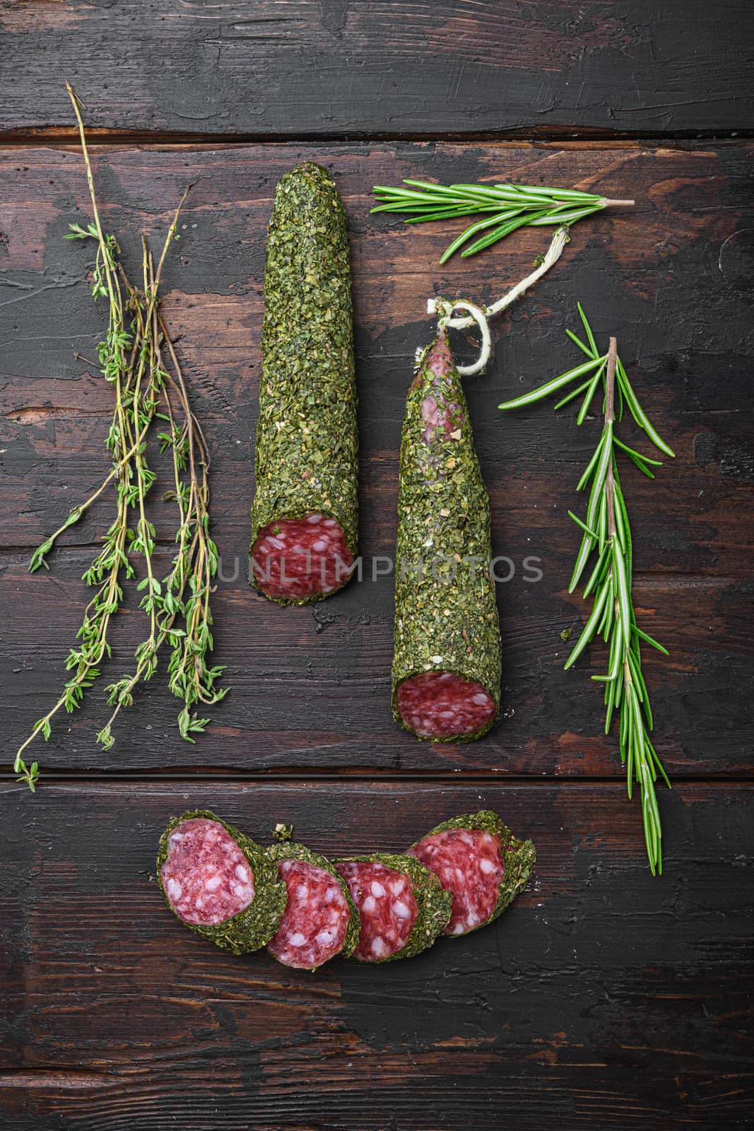Traditional sausage salami fuet, cut to slices on old wooden table, top view.