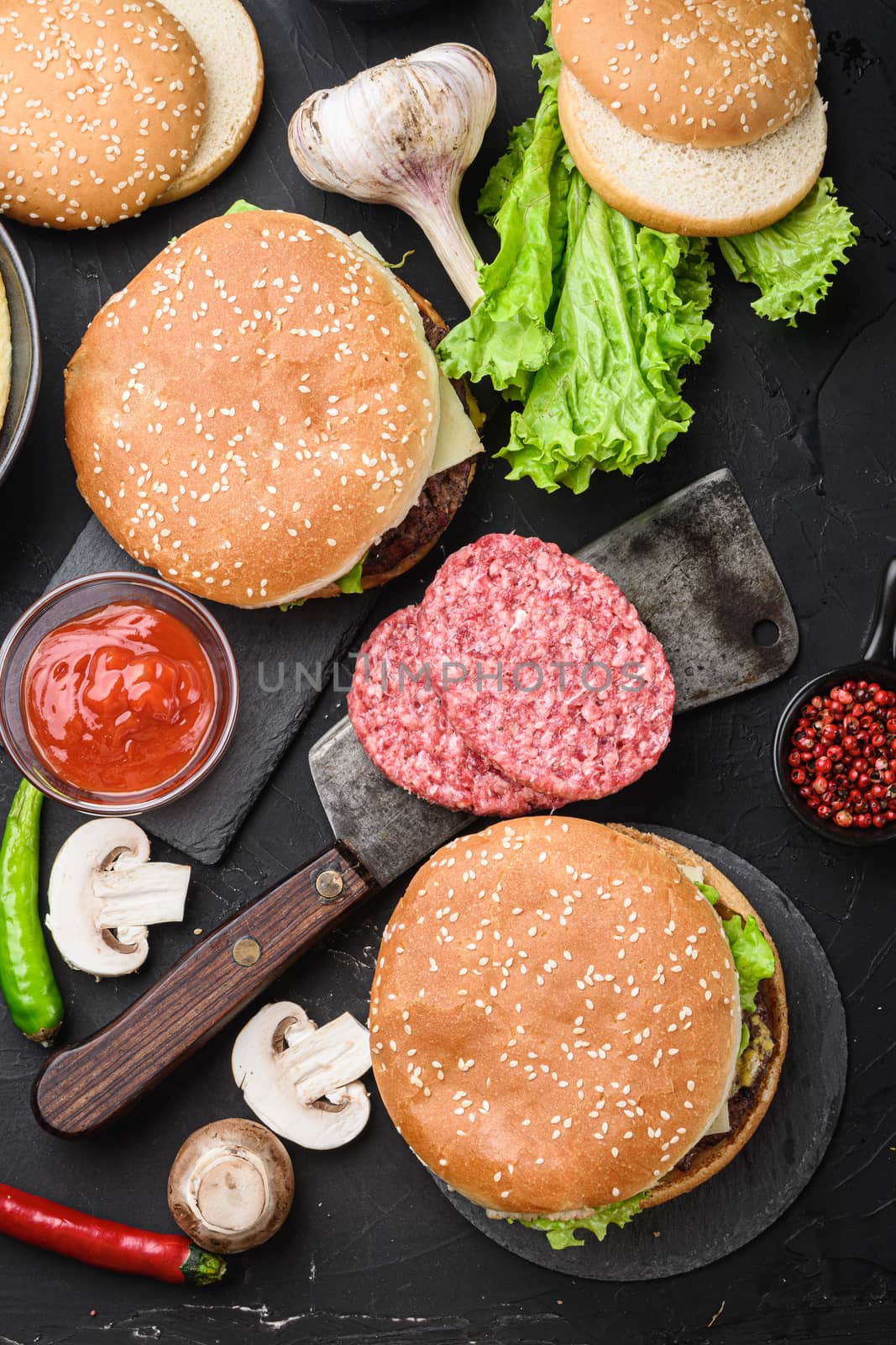 Ground beef steaksand two burgers on black background, flat lay.