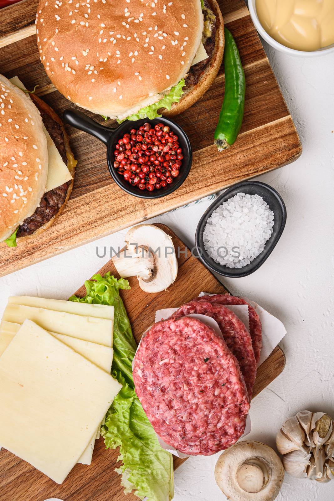 Burger with beef for grill on white textured background.