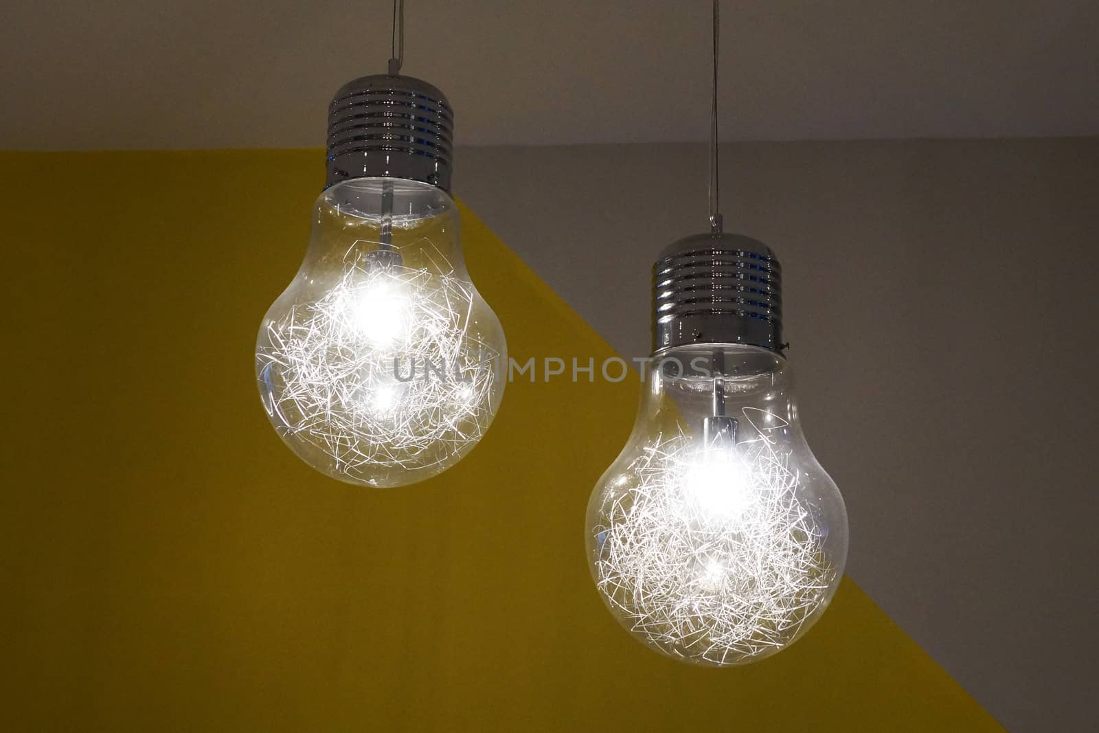 two burning chandeliers in the form of ordinary bulbs on the ceiling