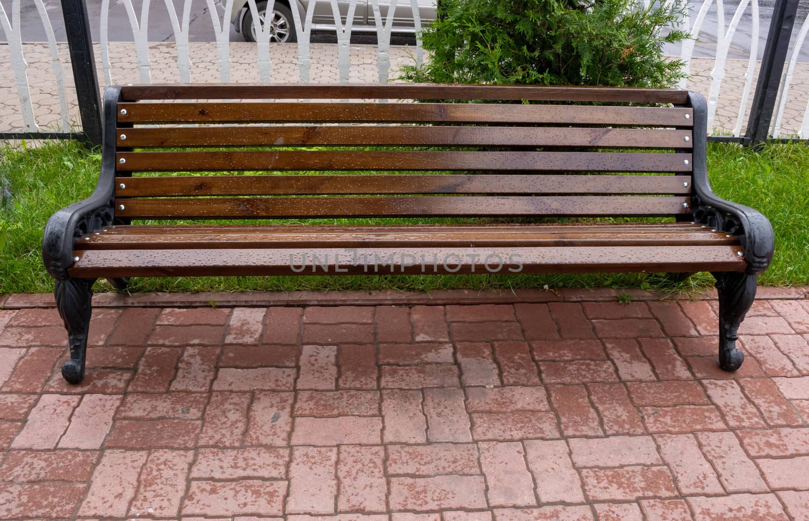 A rain-soaked brown bench in an autumn Park.