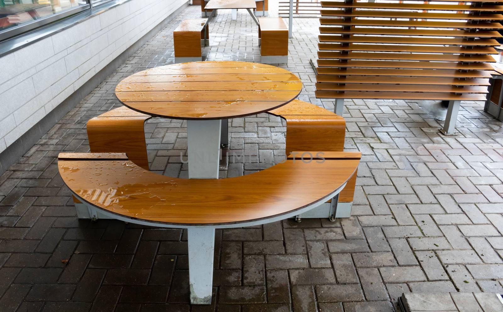 Round light brown table, outdoor roadside cafe on an autumn day.