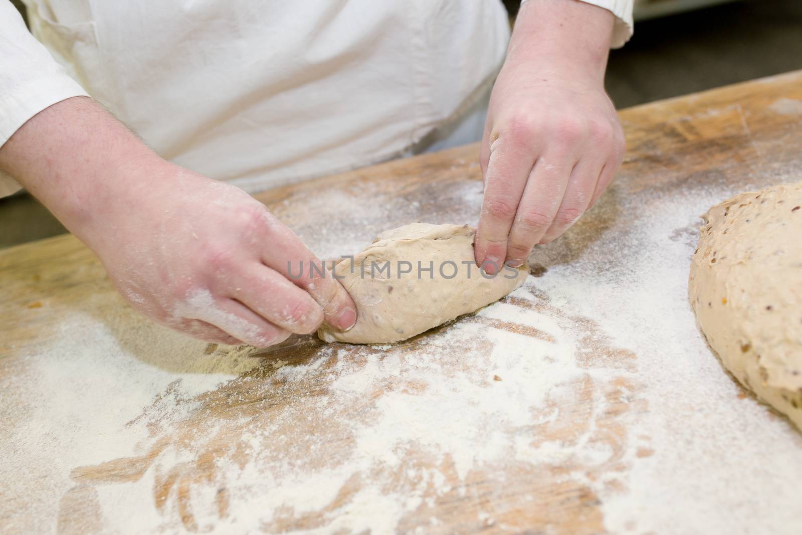 Close-up. Baker makes baked goods, shapes dough on the desktop.