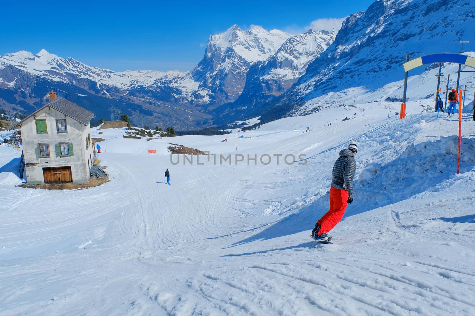 Skier skiing downhill in high mountains Kleine Scheidegg station at Switzerland