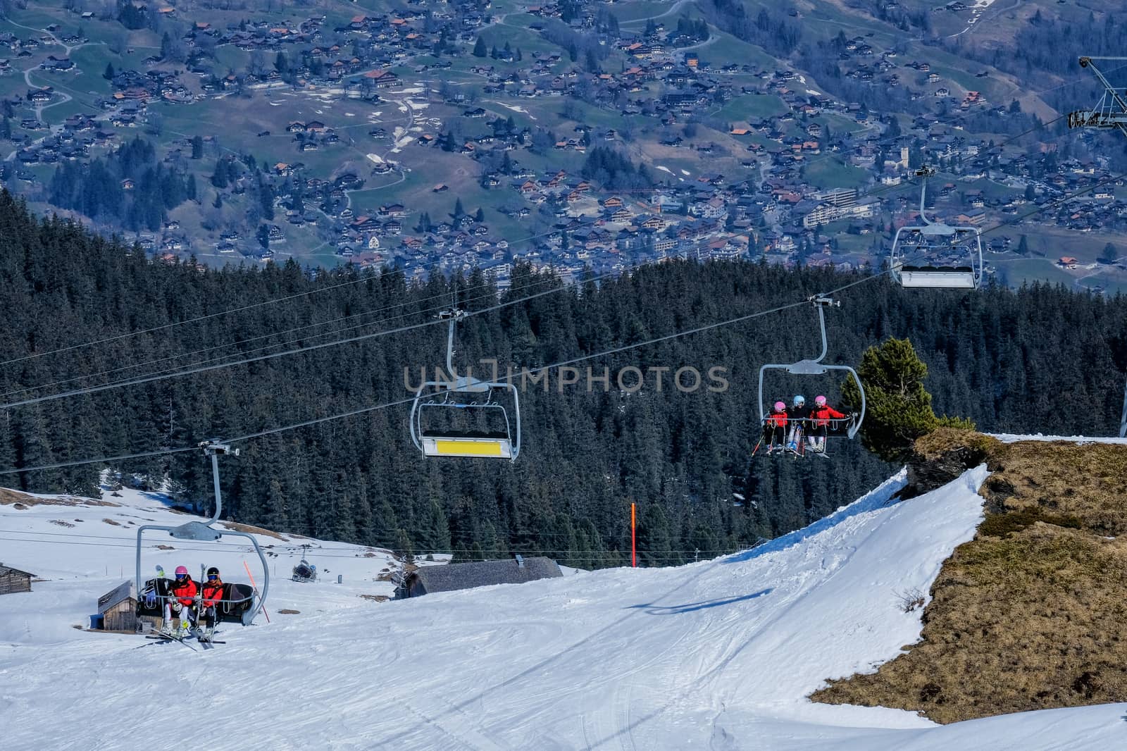 Skier sitting at ski chair lift in high mountains in Switzerland