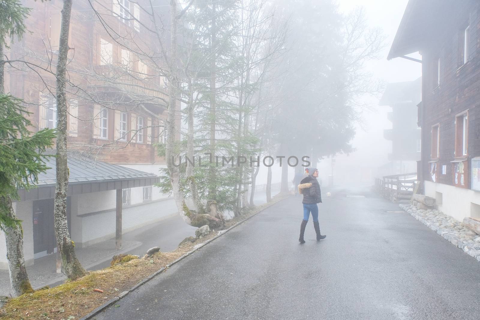 Young beautiful cheerful woman on old street at town in fog