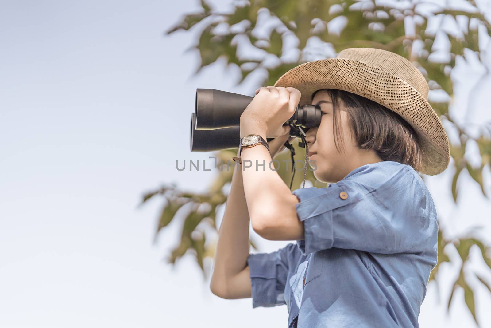 Close up Woman wear hat and hold binocular in grass field by stoonn