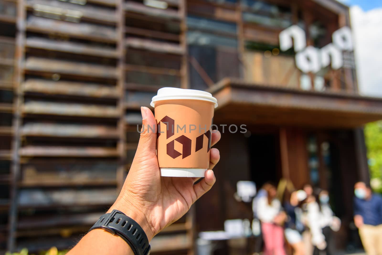 The man hand show a cup of hot coffee of NANA Hunter Coffee Roasters coffee brand by rukawajung