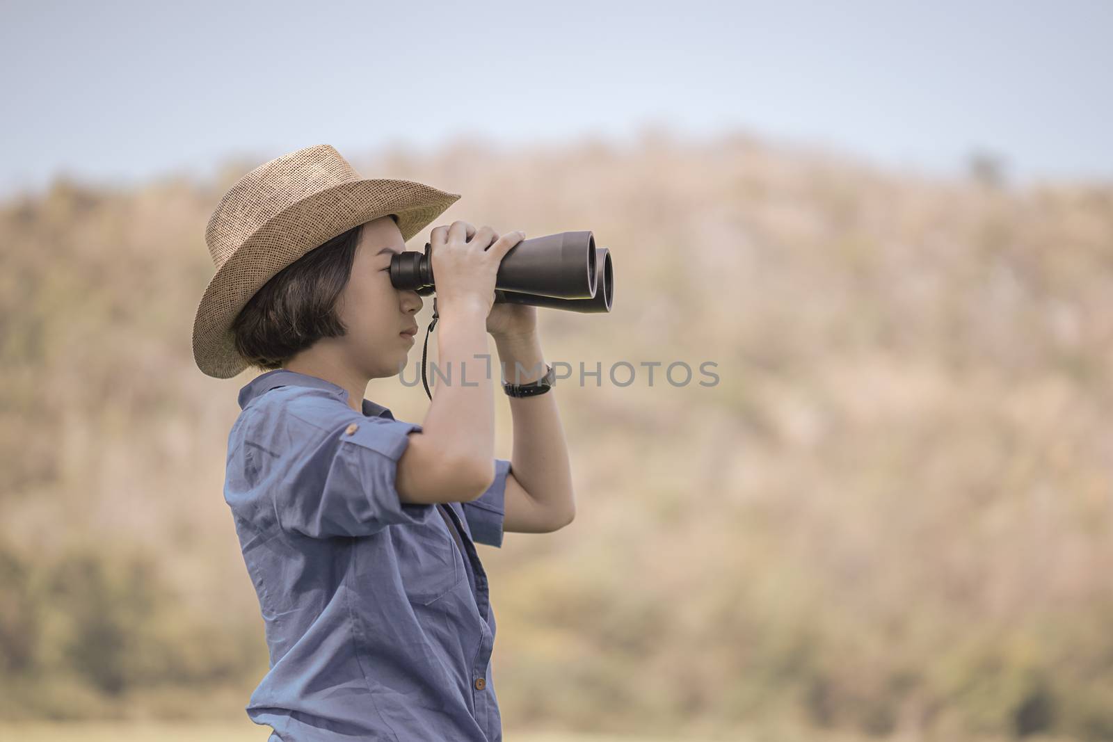 Woman wear hat and hold binocular in grass field by stoonn