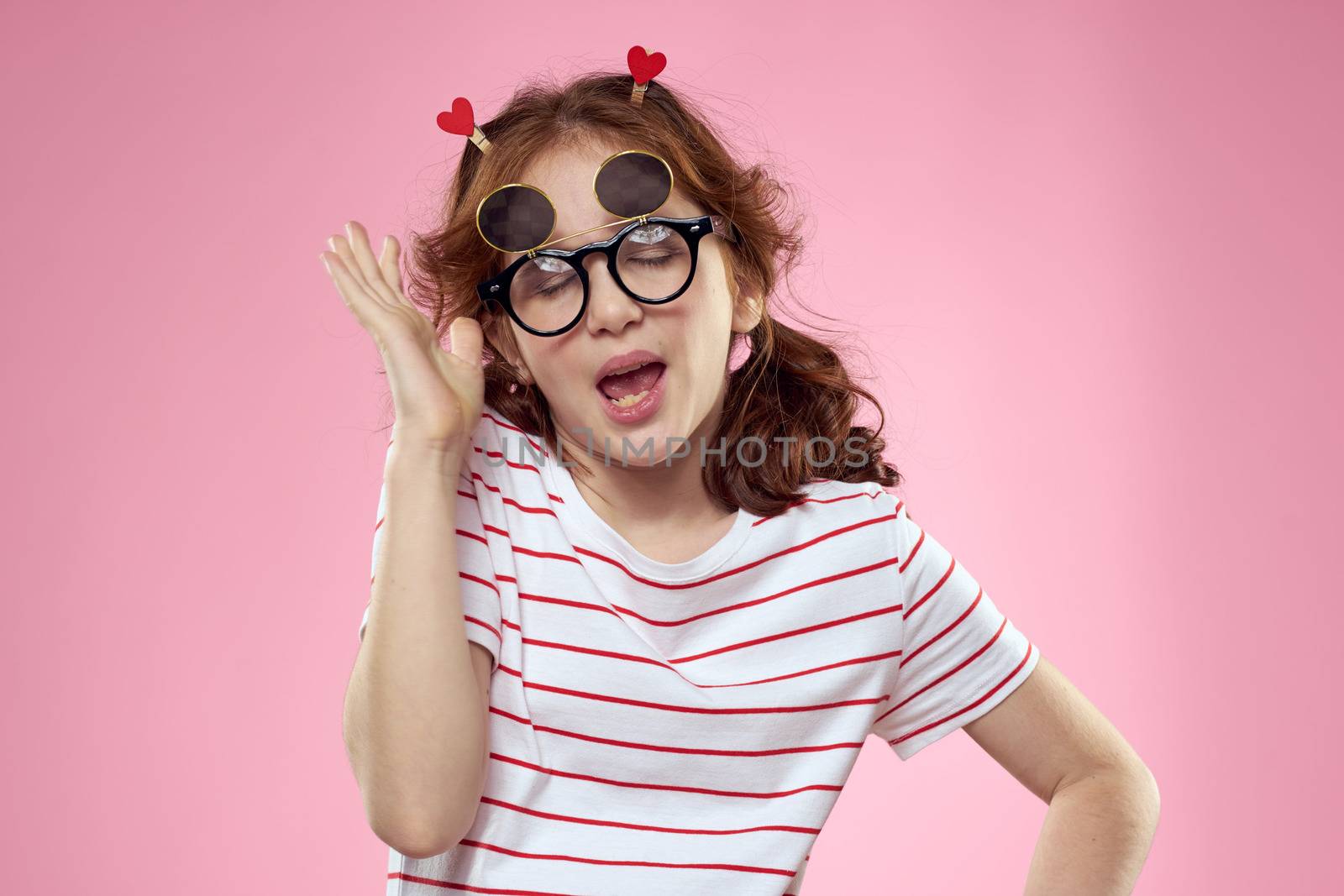 Cheerful girl with pigtails sunglasses striped t-shirt lifestyle pink background by SHOTPRIME