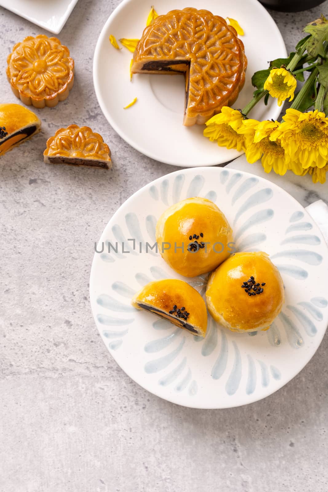 Tasty baked egg yolk pastry moon cake for Mid-Autumn Festival on bright cement table background. Chinese traditional food concept, close up, copy space.