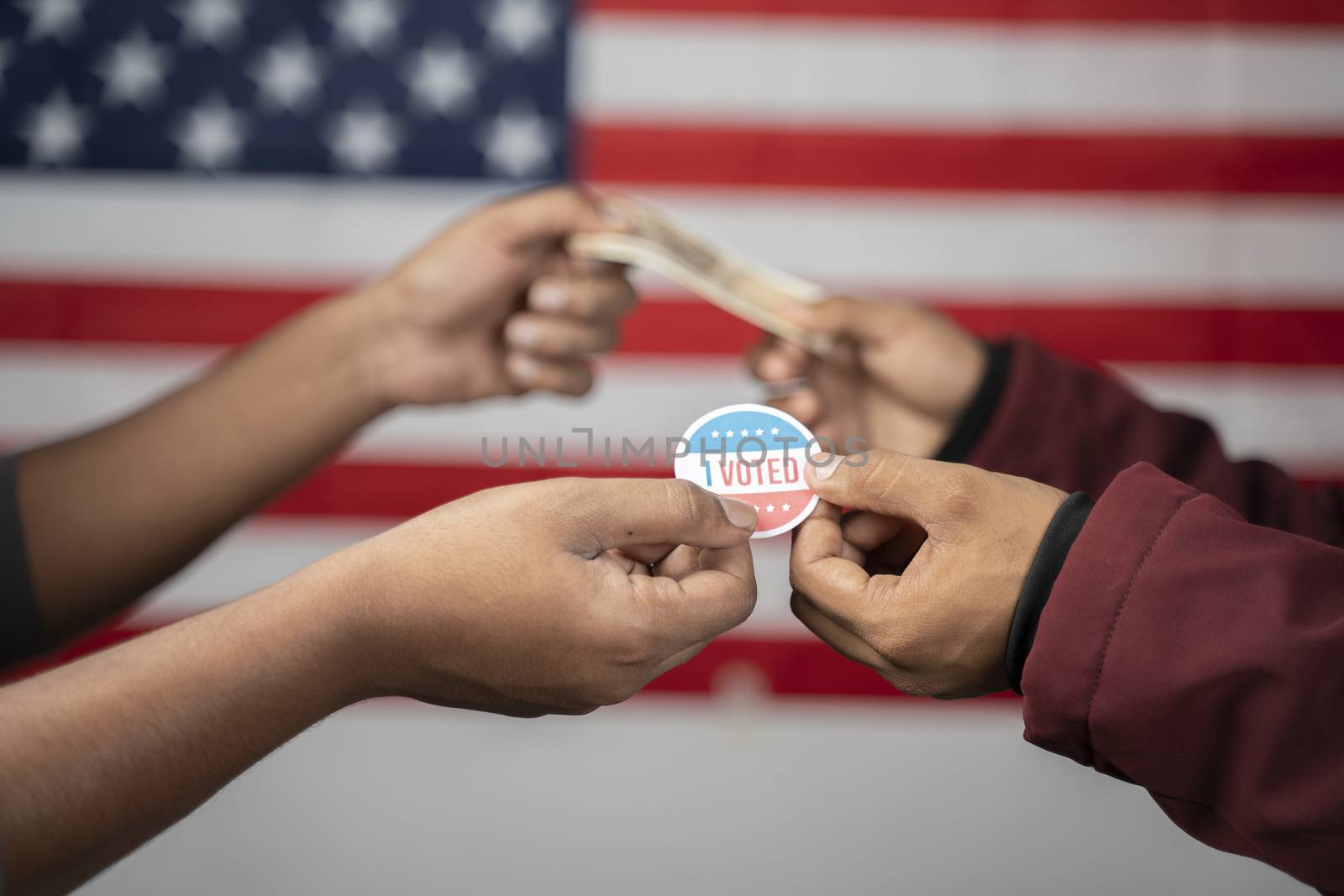 concept of buying votes in US election showing by exchanging I voted sticker with money on US flag as background. by lakshmiprasad.maski@gmai.com