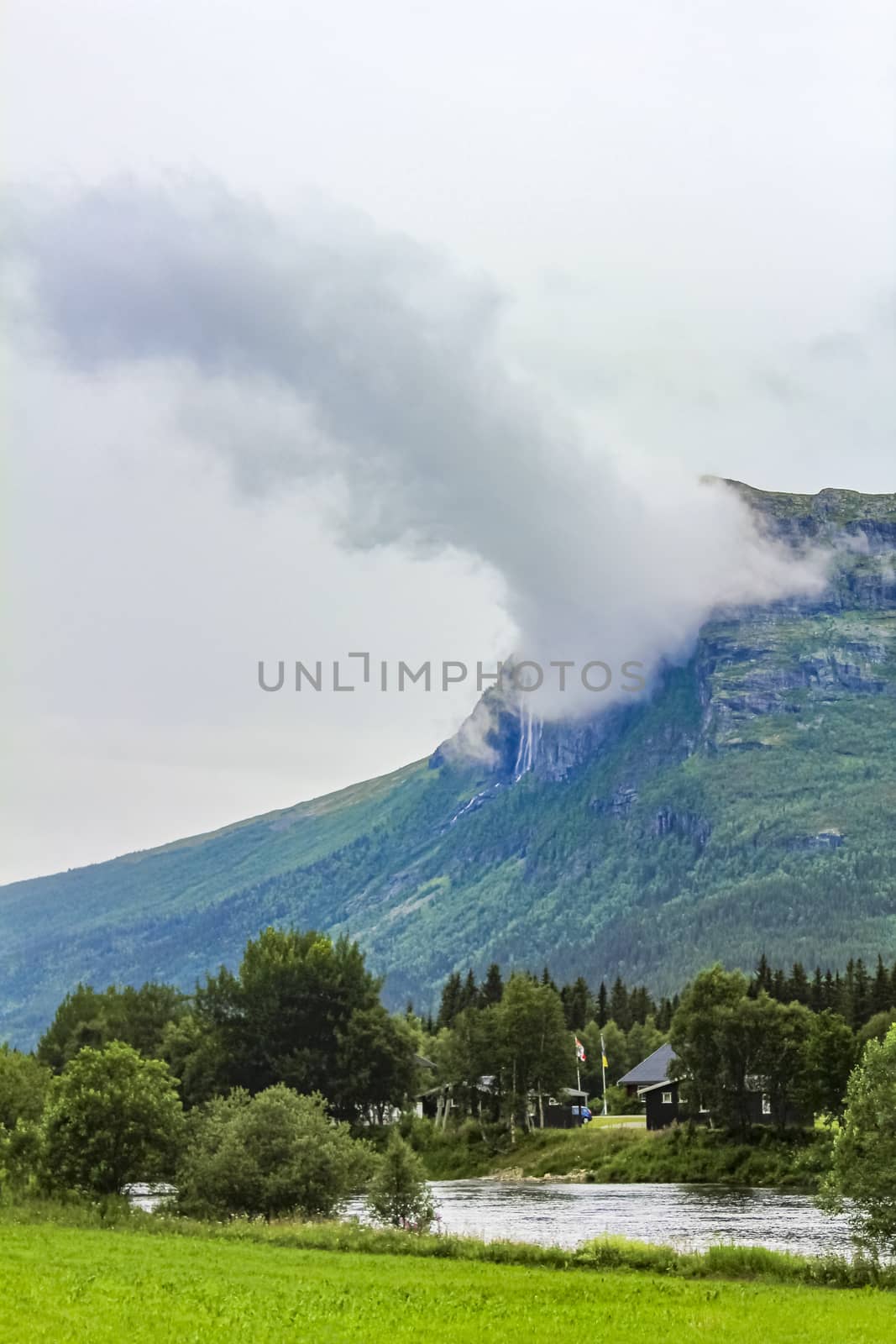 Double Hydnefossen waterfall shrouded in incredible clouds and fog, Norway. by Arkadij