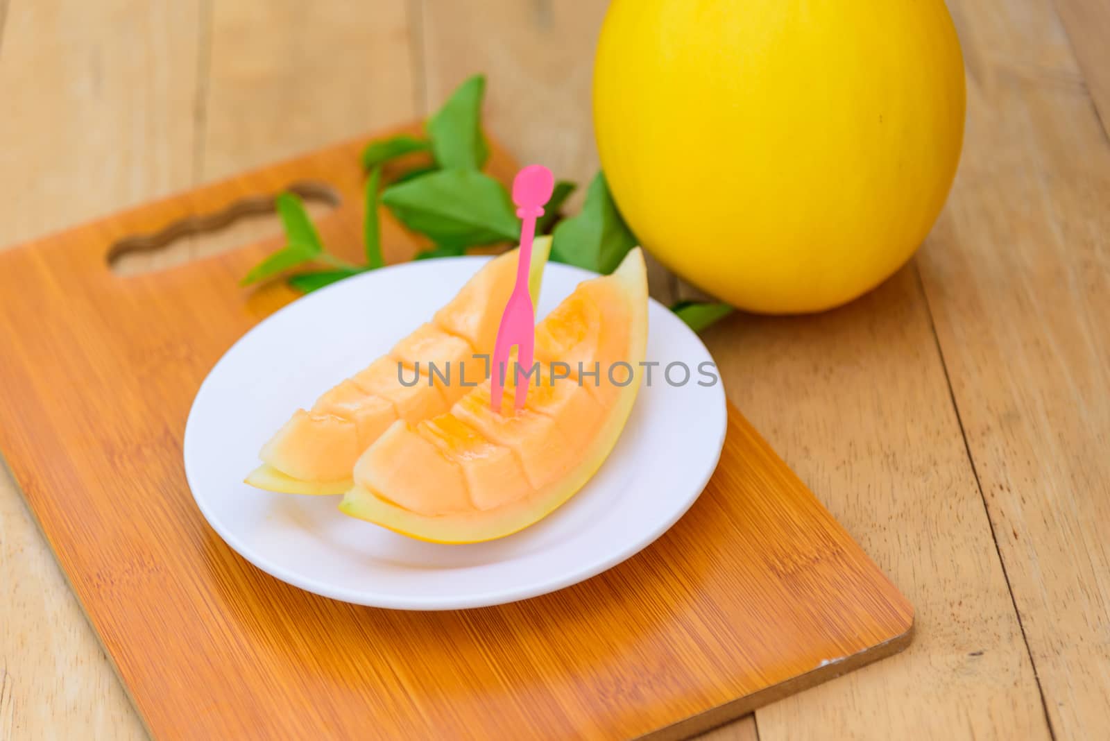 fresh golden melon on wood plate by rukawajung