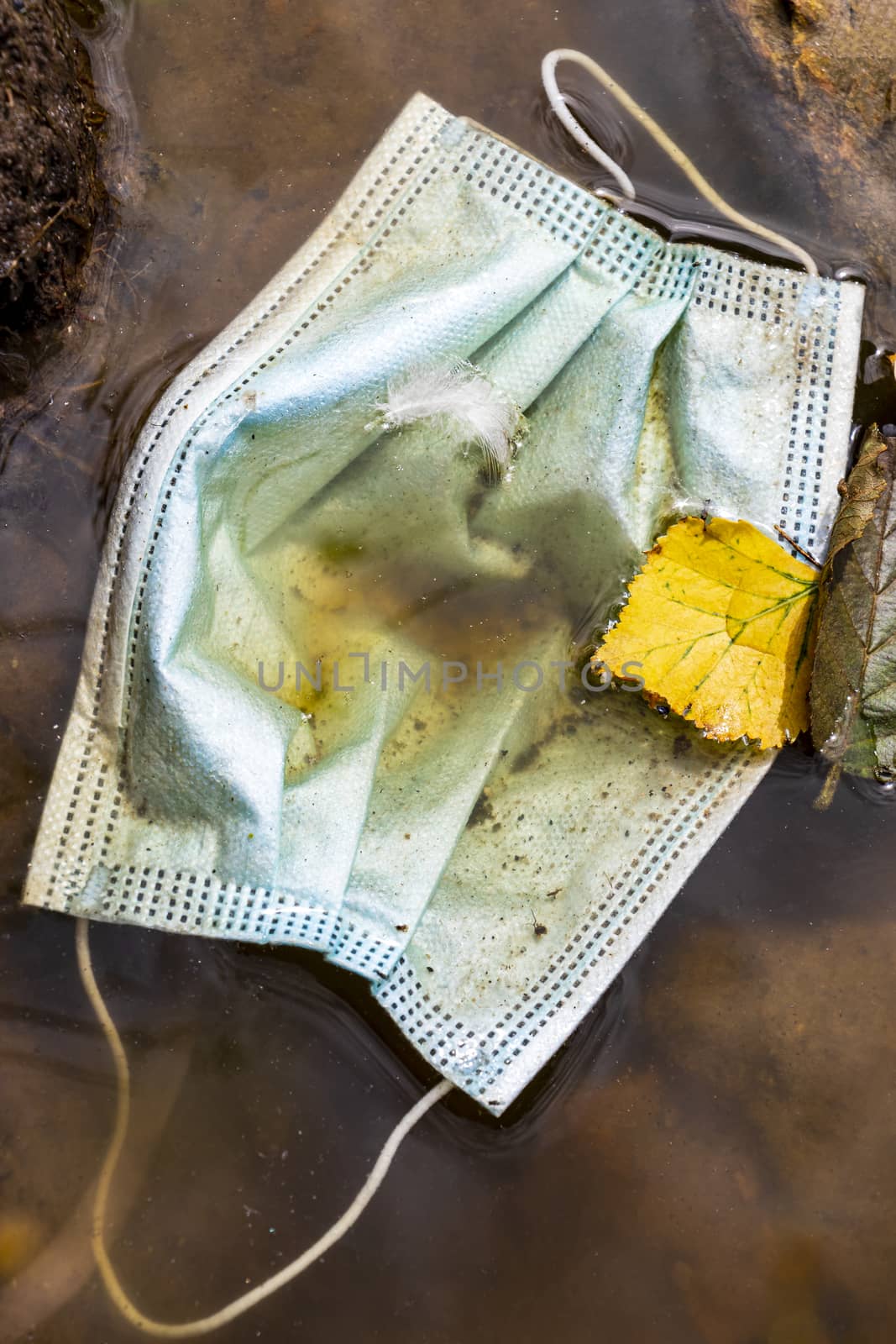 Surgical masks in nature lake pond. Corona virus pollution. Covid19. by Arkadij