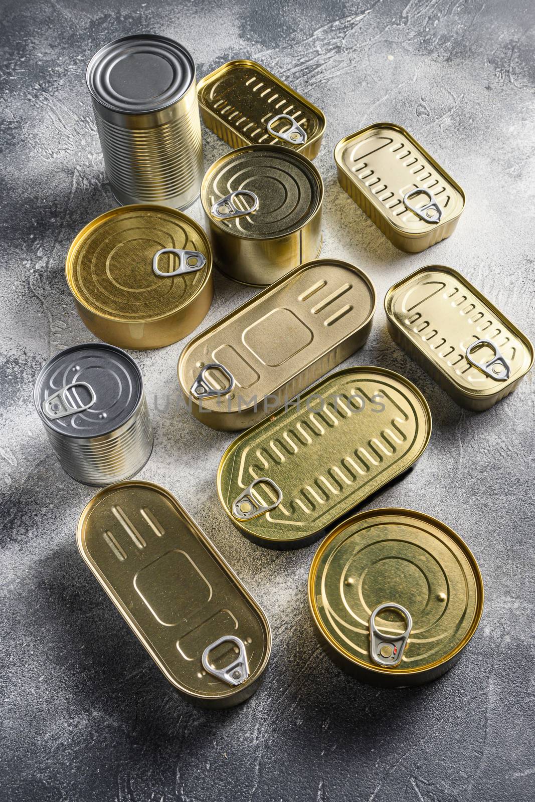 Assortment of cans of canned with different types of shapes top view on grey rustic background side view.