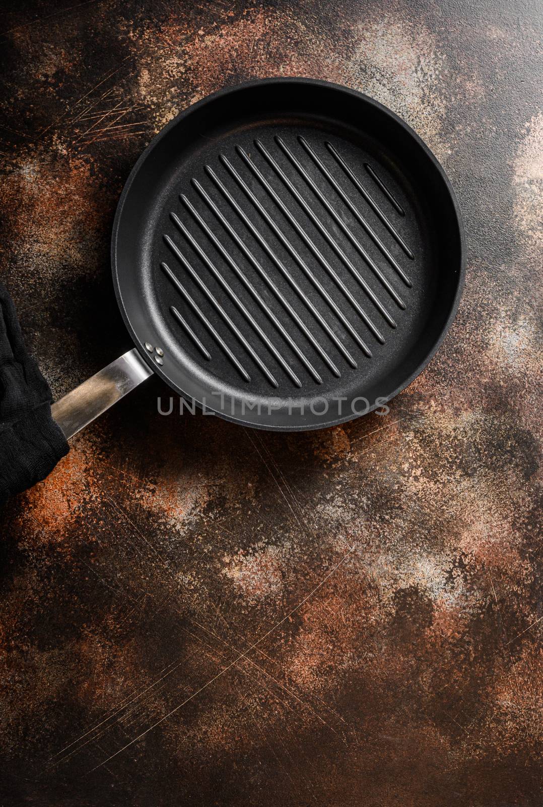 empty cast-iron grill pan skillet and linen cloth on metal rustic table top view space for text. by Ilianesolenyi