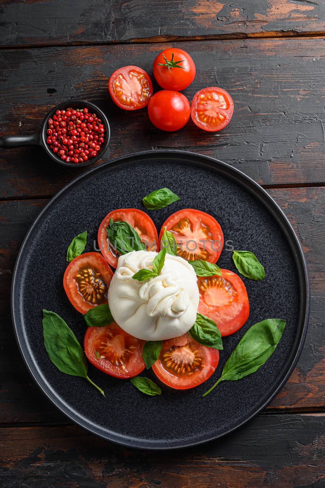 Handmade burrata cheese served with fresh tomatoes and basil leaves traditional italian Salad vertical top view. wood table old rustic. by Ilianesolenyi