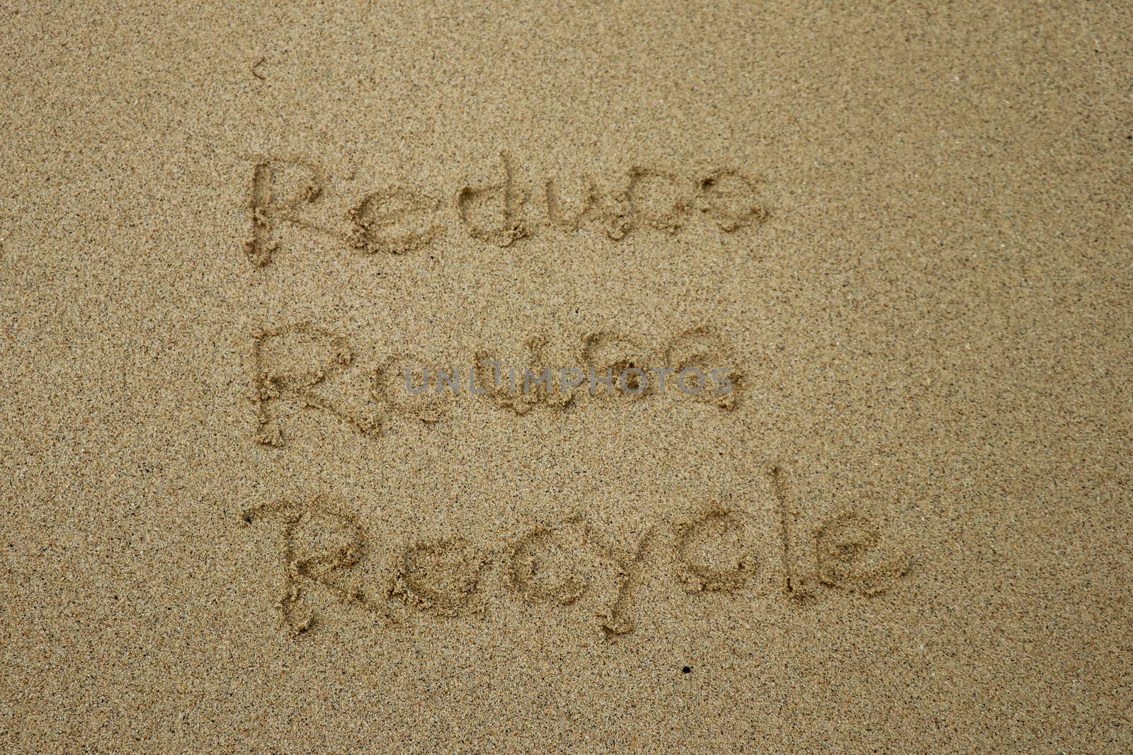 reduce reuse recycle concept drawn on sand, sustainability.