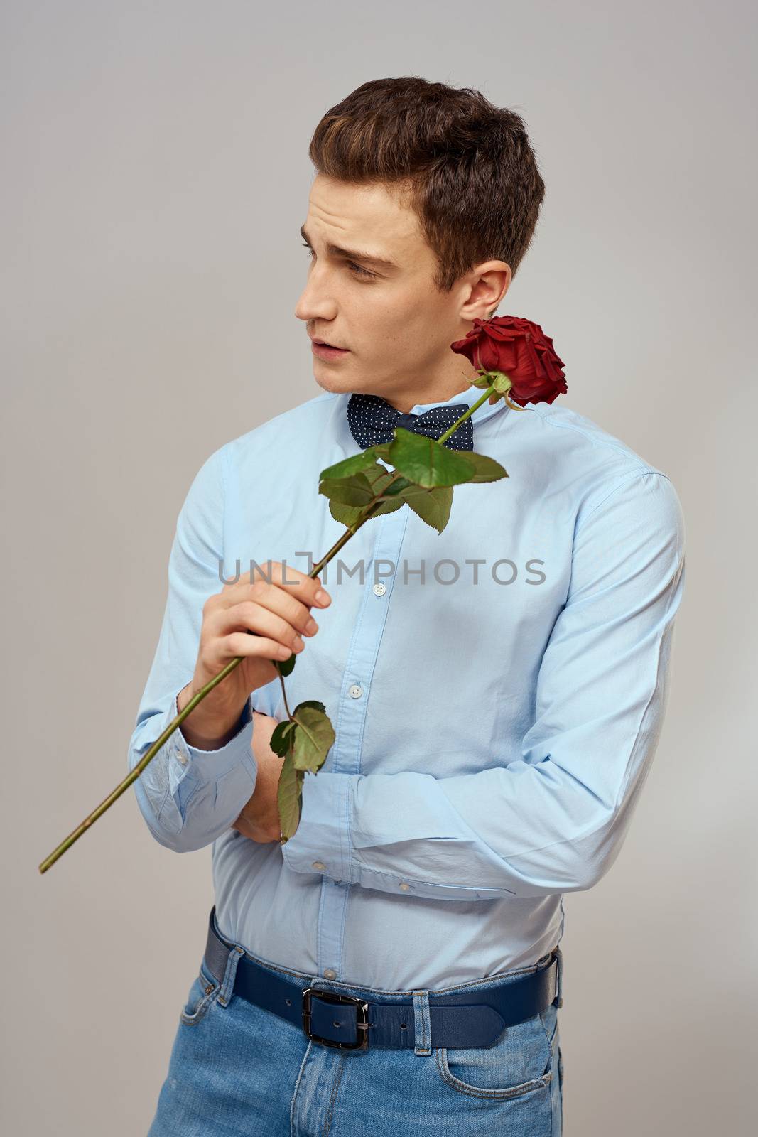 romantic man with red rose and light shirt pants suit. High quality photo