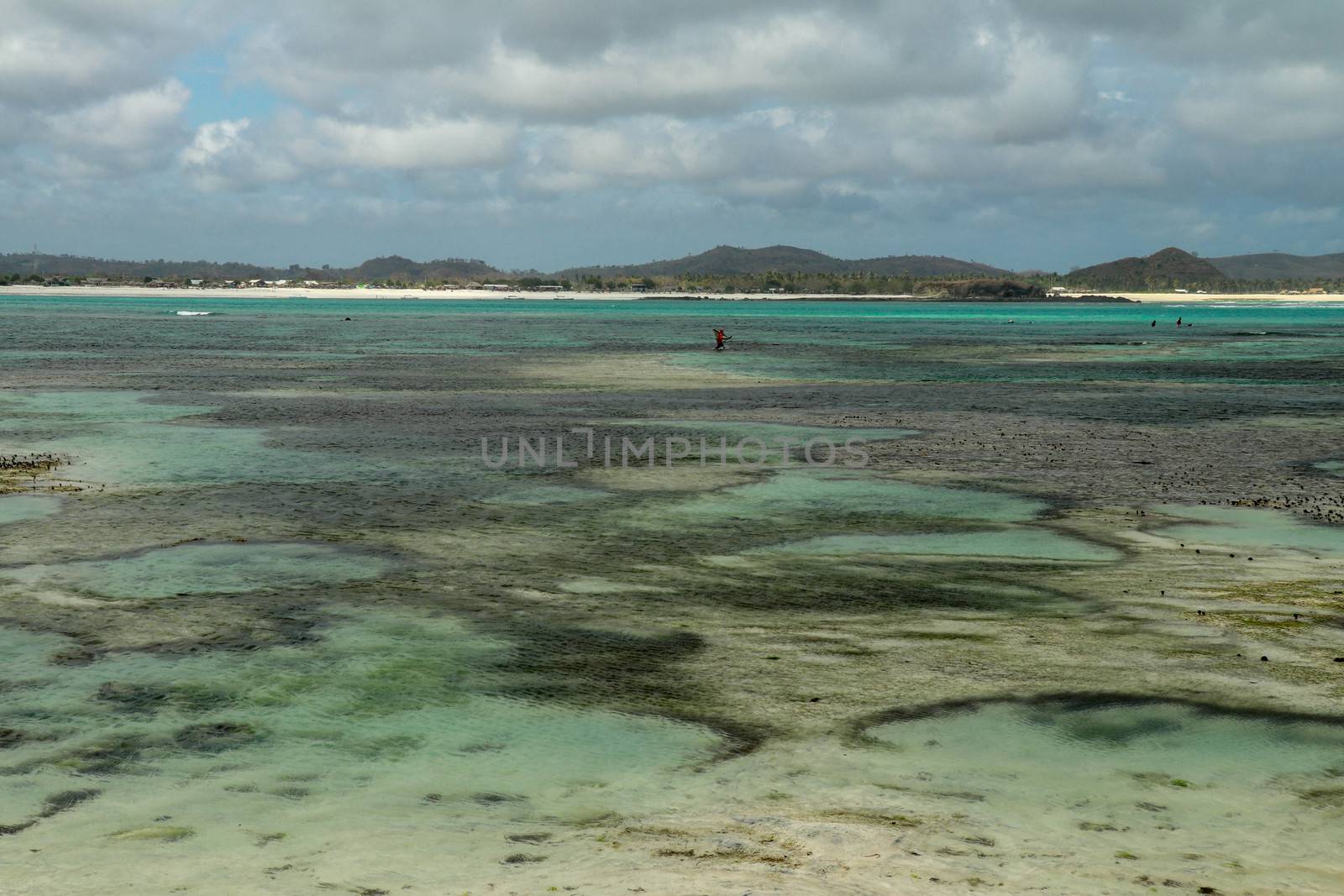 small tide pool during low tide at the ocean in Tanjung Aaan, Lombok, Indonesia. Roral reef around an island in Indian ocean during low tide, which makes amazing scenery.