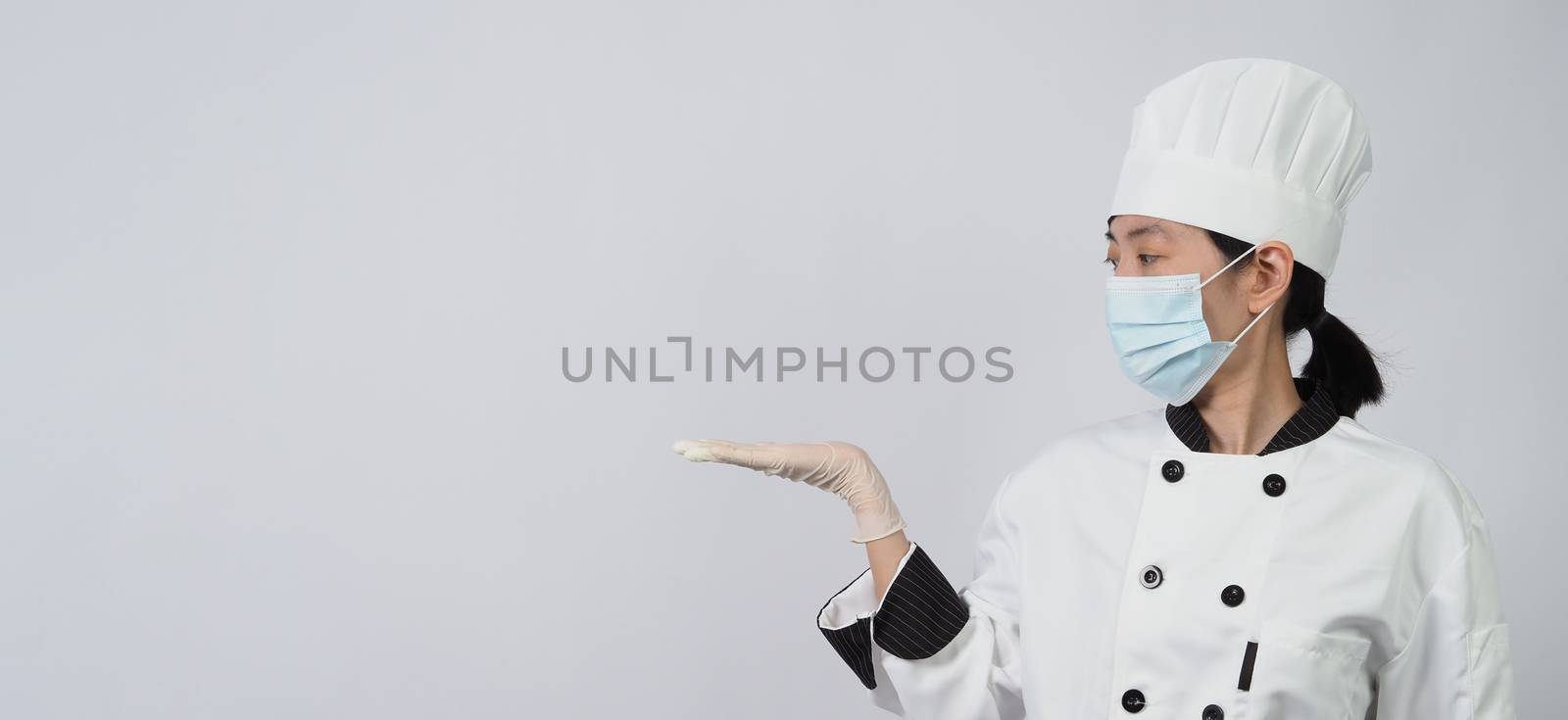 Asian woman chef in uniform with medical face mask and glove. by gnepphoto