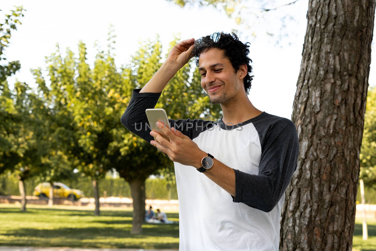 Portrait of handsome young man using his mobile phone outside